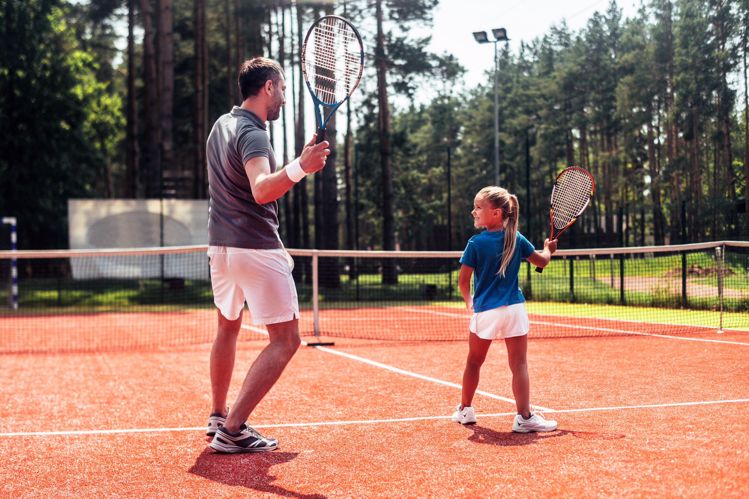 Papa und Tochter spielen Tennis
