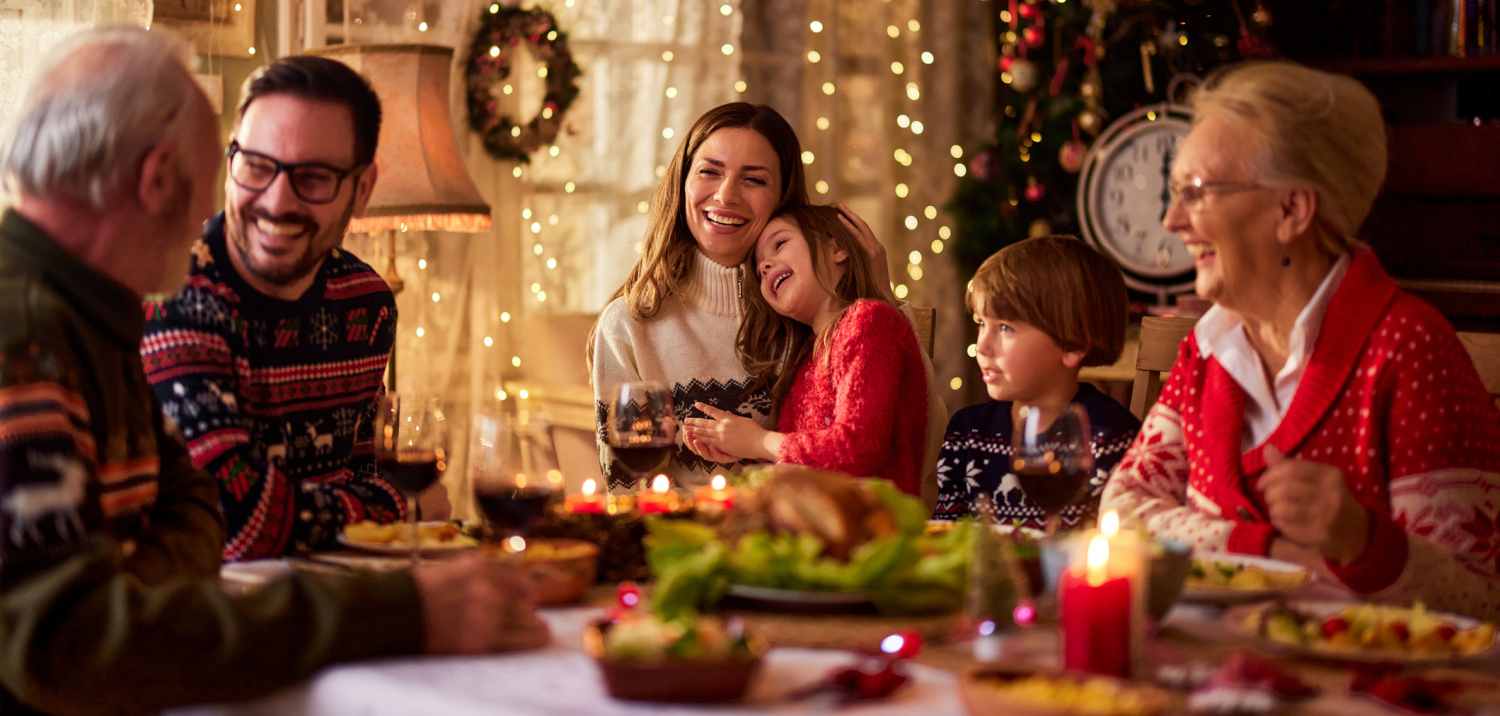 Familie sitzt an einem gedeckten Tisch