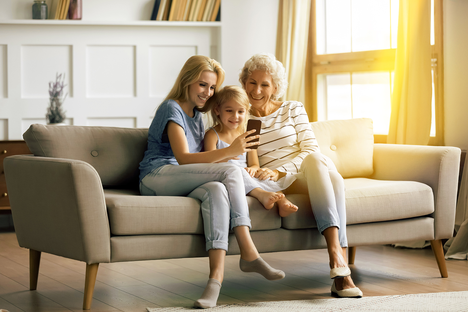 Familie sitzt auf dem Sofa und schaut in den Laptop