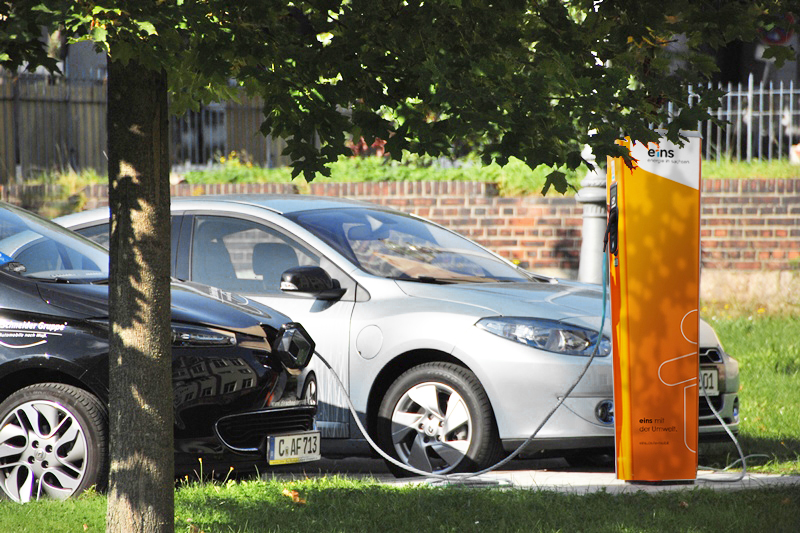 Parkplatz mit Ladesäule and der zwei Autos laden