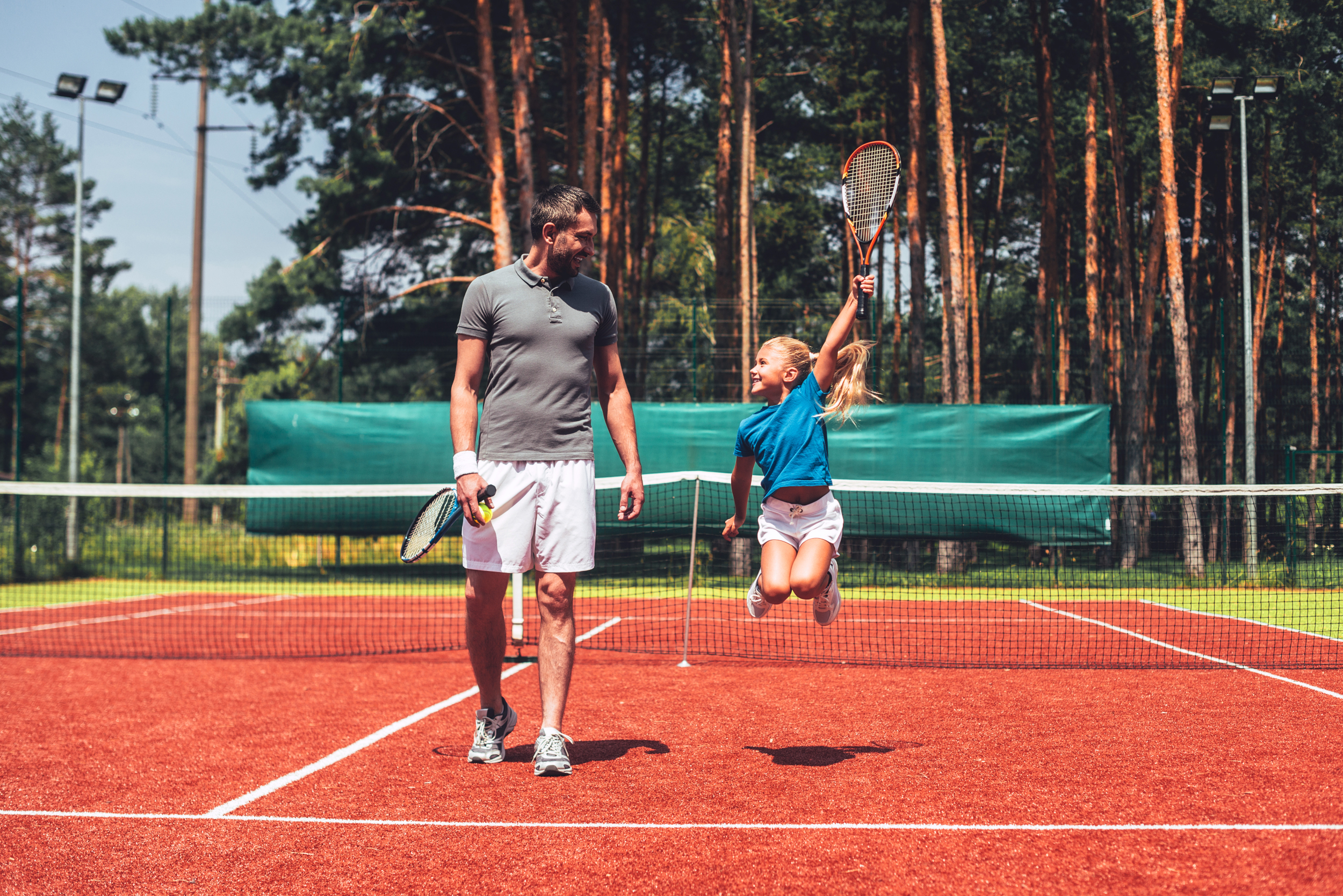 Papa und Tochter spielen Tennis