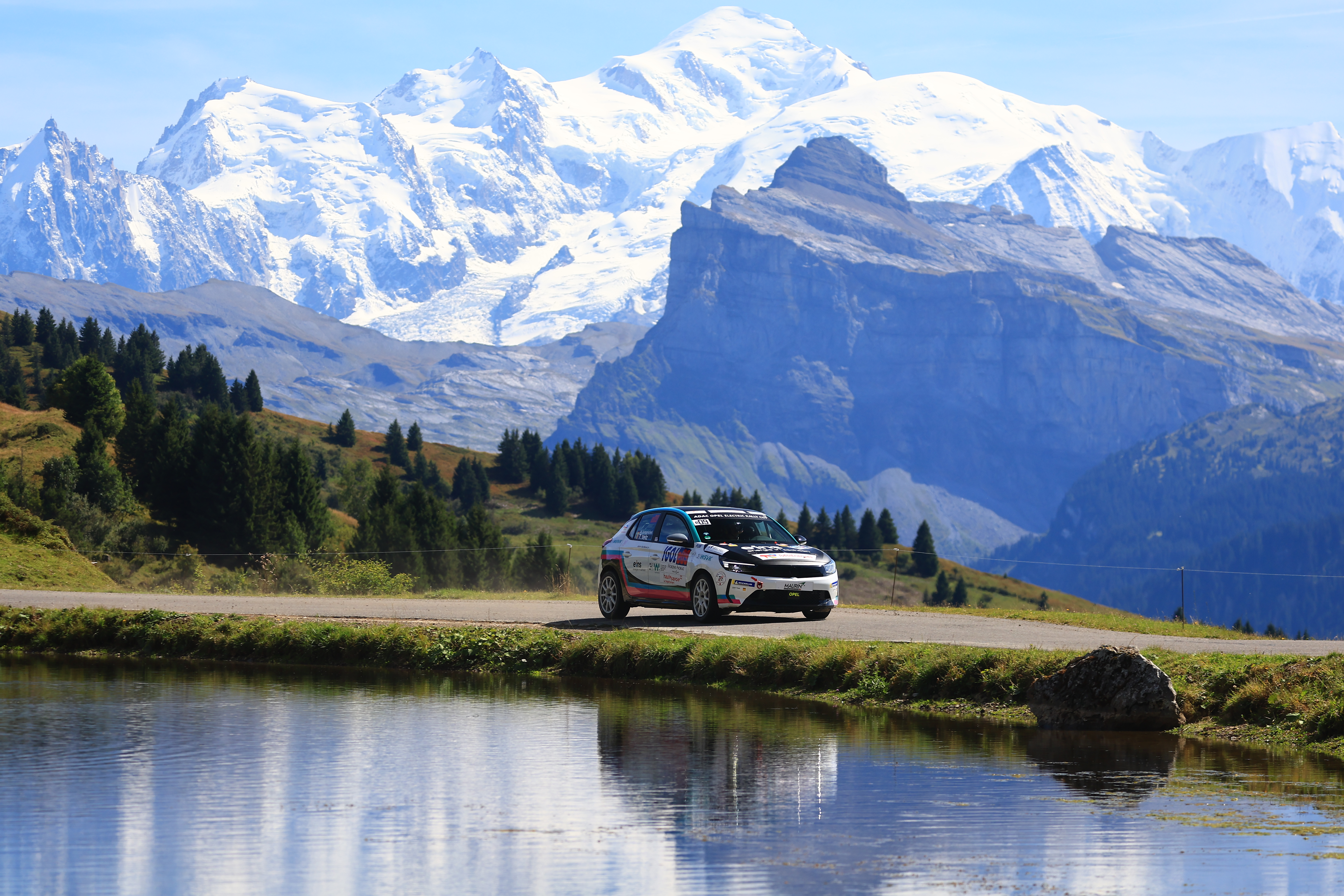 Rallye-Auto steht vor einem Bergpanorama.