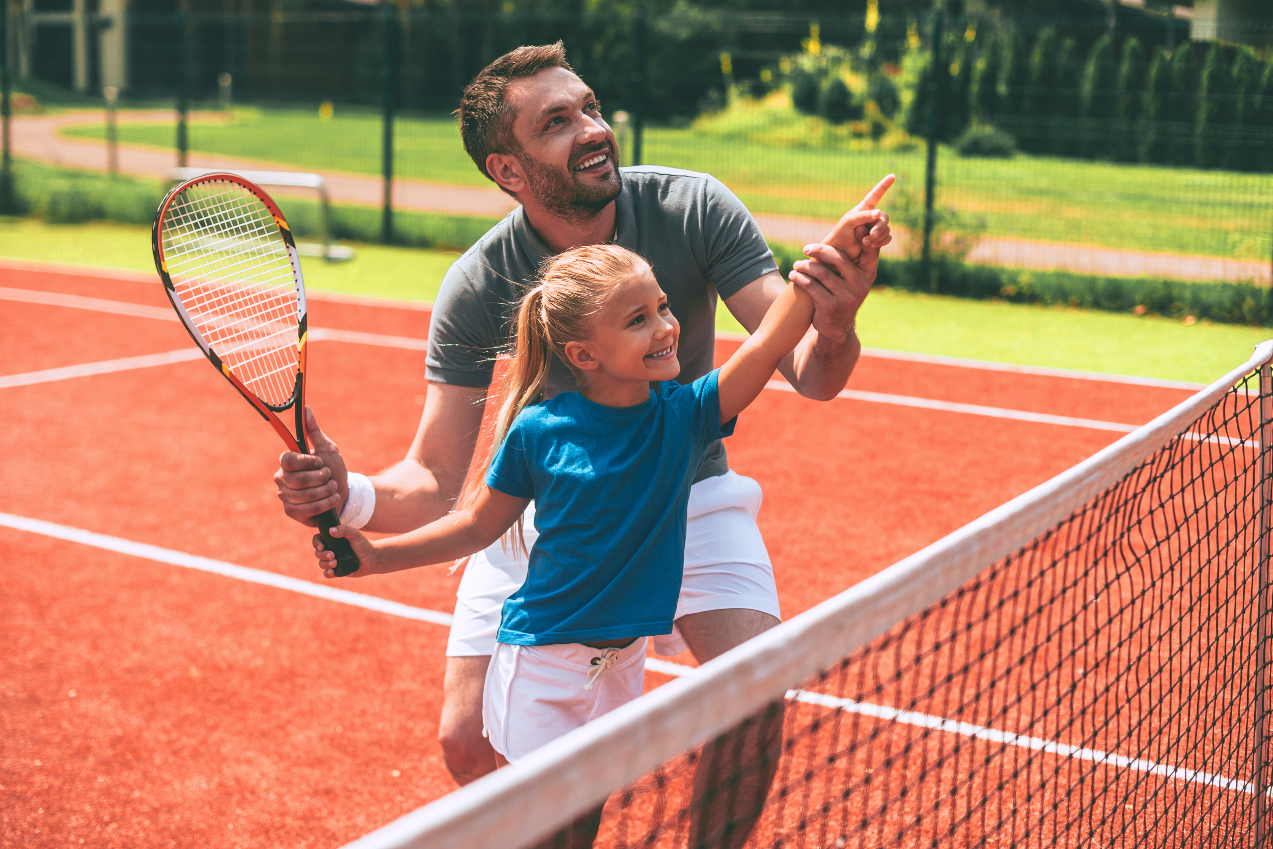 Papa und Tochter spielen Tennis