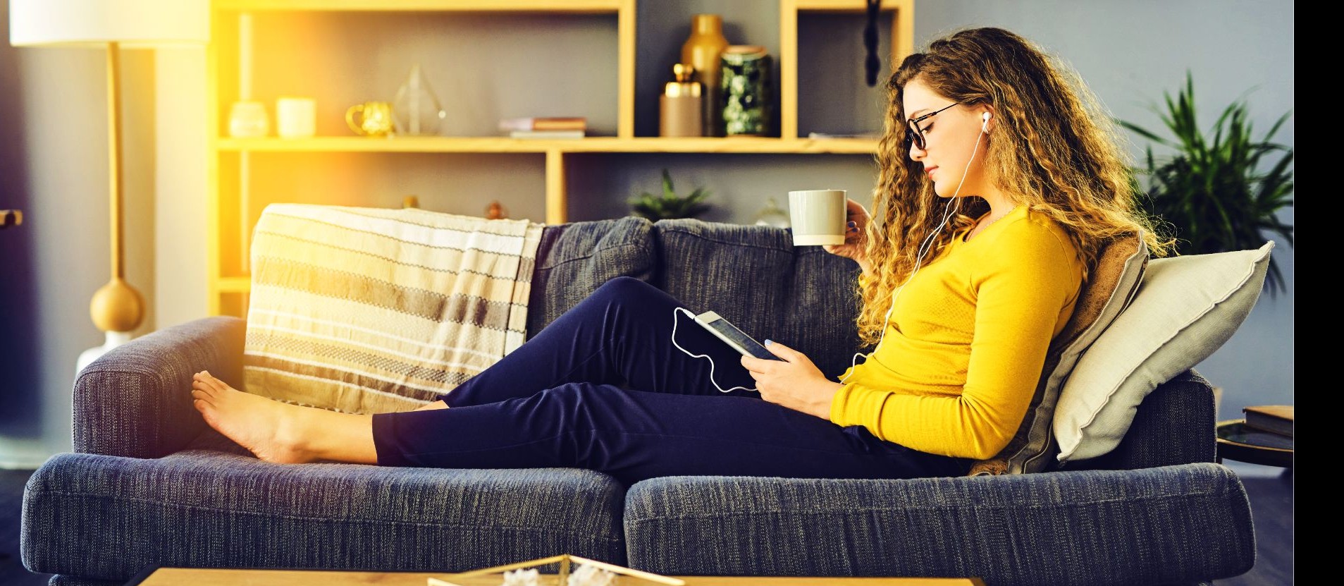 Eine Frau liegt auf ihrem Sofa und checkt die Service-Zeiten auf der eins-Website