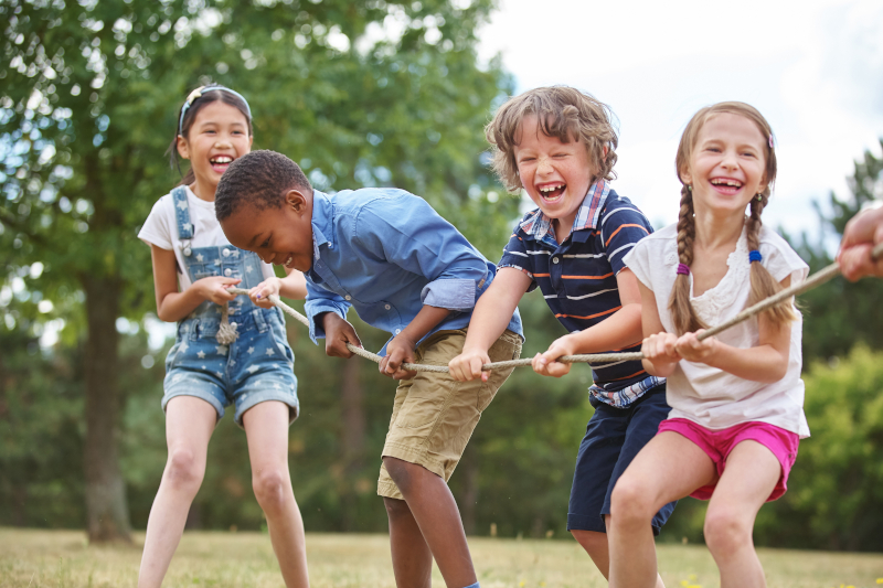 Spielende Kinder beim Seilziehen