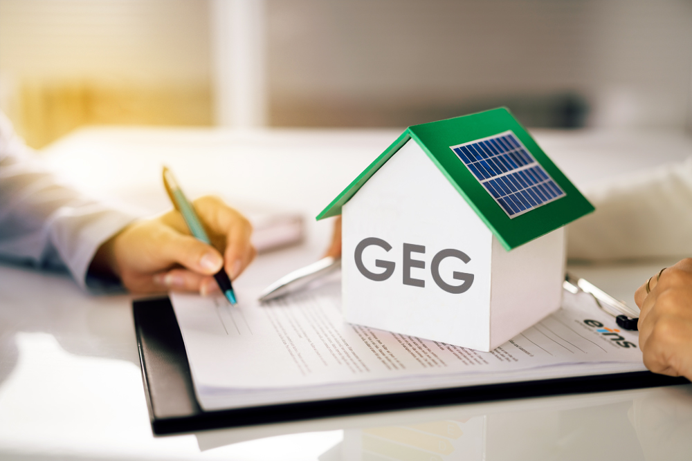 Mann sitzt am Schreibtisch und unterschreibt ein Formular zum Gebäudeenergiegesetz 