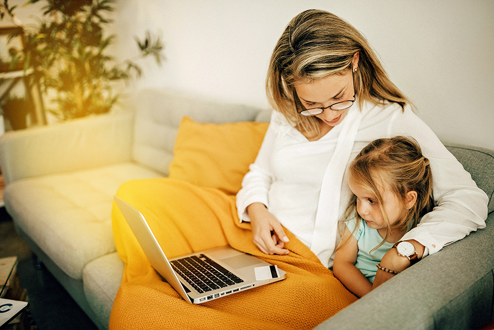 Mutter mit Kind schauen auf Laptop