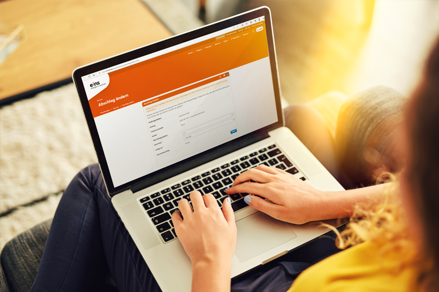 Frau tippt auf Laptop und ist auf der Online-Service Seite von eins.
