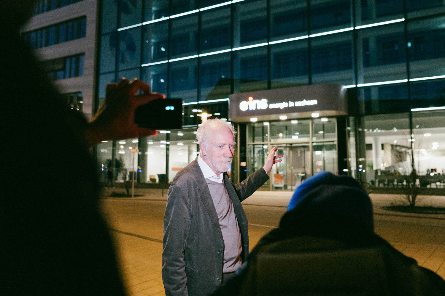 Künstler zeigt auf sein Kunstwerk