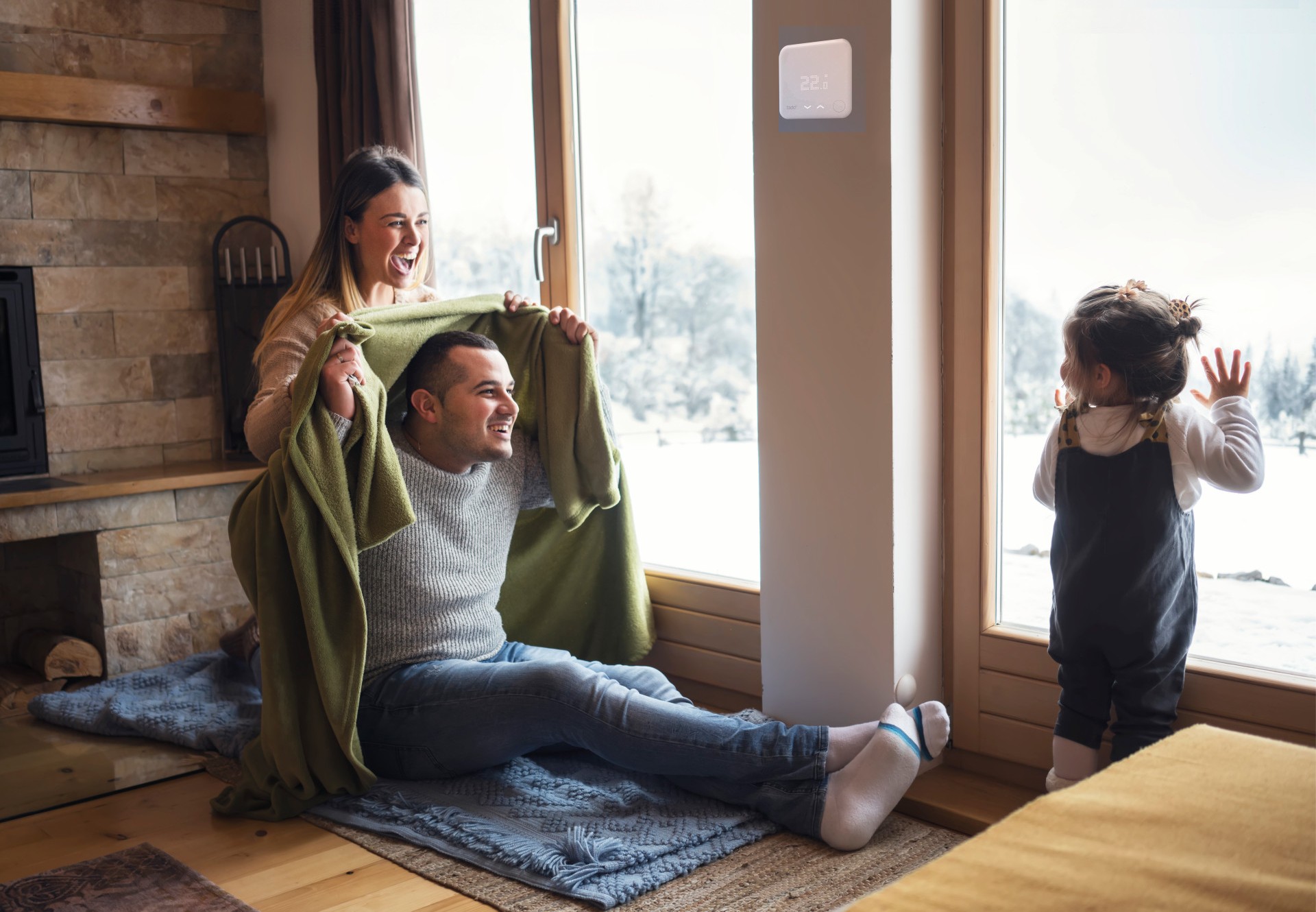 Familie sitzt auf Fußboden, während es draußen kalt ist