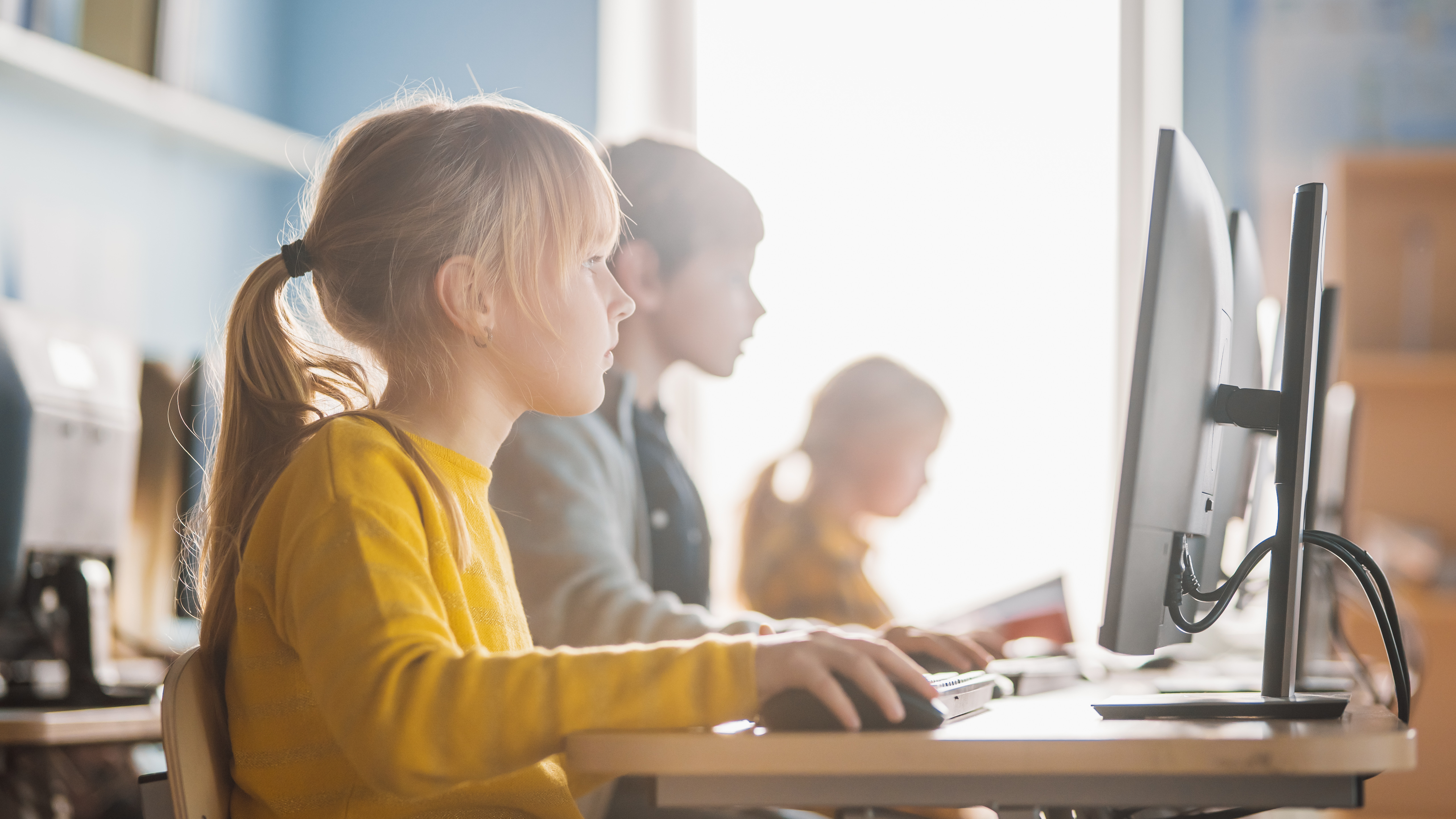 Schüler sitzen im Klassenzimmer vor Rechnern